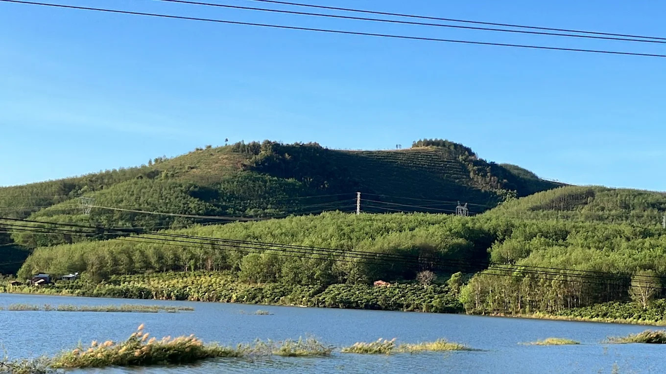 Lòng hồ xanh ngát phản chiếu đồi núi trập trùng – cảnh sắc Tây Nguyên dịu dàng và đầy sức sống.
