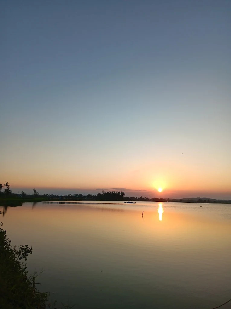 Mặt nước phẳng lặng, ánh nắng trải dài tạo nên bức tranh thiên nhiên yên bình và nhẹ nhàng.